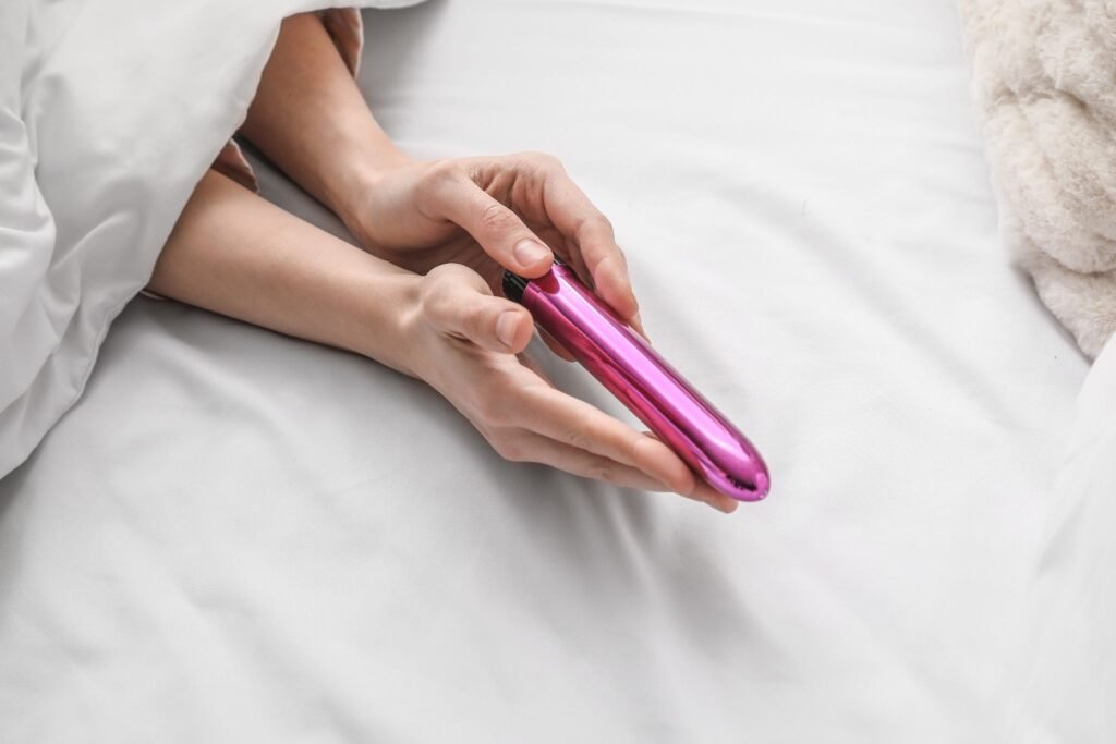 Paar im Bett zeigt Sexspielzeug-Vibrator